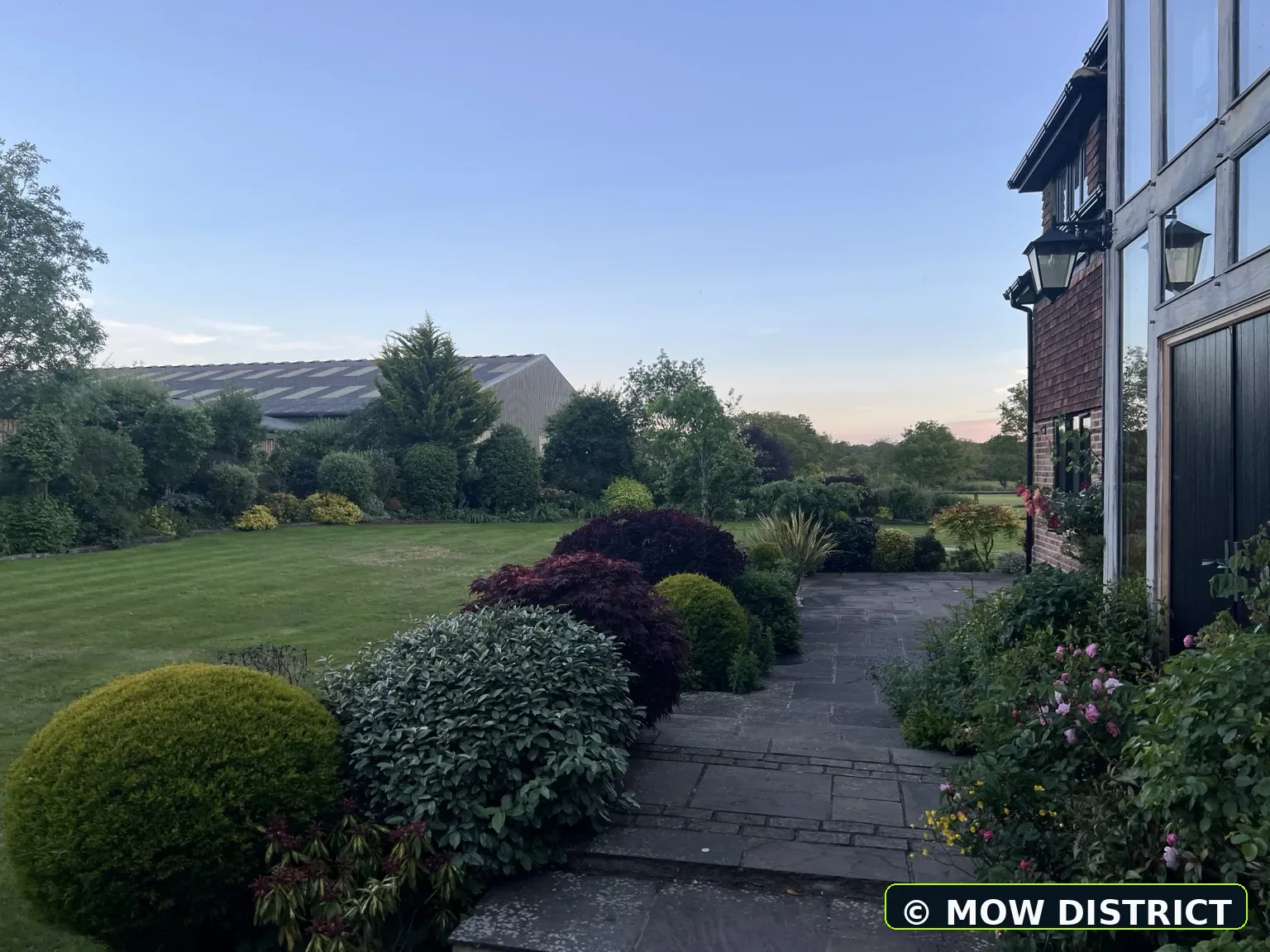 Side lawn and patio area with clean mowing finish